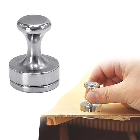 Hand holding Acoustic Guitar Panel Repair Magnet With Handle For Cracked Panel Fixes, metal tool on wooden surface