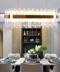 Slick Fresh Oval Glow Dimmable LED Pendant Light Adjustable Hanging Ceiling Fixture For Dining Room And Kitchen Top Shelf Gold Steel Chandelier with crystal accents above a dining table.