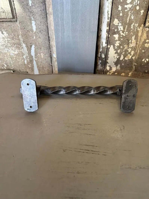 Close-up of Set Of 2 Oversized Cast Iron Door Pull Handles With Twisted Forged Design for gate rustic barn shed exterior.