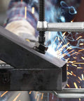 Beefy 12 Inch All Steel Bar Clamp With 2660 Nominal Clamping Force in use during metalwork with welding sparks visible