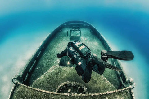 Underwater diver wearing Zen Deluxe Single Tank Scuba BCD With Narrow Zen Wing exploring sunken shipwreck.