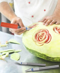 Person carving watermelon with 13 Piece Precision Craft Knife Set With Interchangeable Blades And Ergonomic Handles Ideal For DIY Projects.