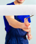 Ultra Smooth Small Paint Roller Cover With Replaceable Sleeve Hella Tough No Drip Design in use, showing a worker's hand holding a metal frame.