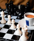 Chess board with white and black pieces, Lavazza espresso cup on the side