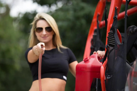 One Half Inch X Eight Foot Self Priming Jiggler Siphon Hose Transfers Gas Water Oil Fast Up To Four Gallons Per Minute No Sweat Quick Transfer Tube held by a woman.