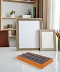 Slick Gray Solid Wood Jewelry Display Tray Featuring 12 Ring Slots on a desk with decorative items and picture frames.