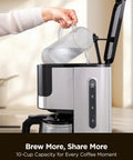 Person pouring water into 10 Cup Drip Coffee Maker With 24 Hour Programmable Timer Glass Carafe And Reusable Mesh Filter