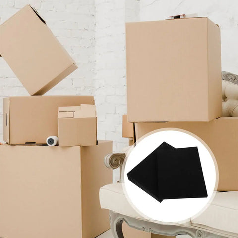 4 Pack Black Hard Foam Blocks 405x305x25mm Shipping Padding Sheets next to stacked cardboard boxes for packaging protection