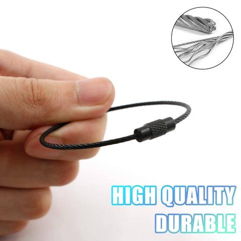 Hand holding a black stainless steel wire keychain, 20 Pcs Black Stainless Steel Wire Keychains 1.5mm Thick Elastic Wire Rope Loops 5.9 Inches Long Heavy Duty Durable Luggage Tag Rings Cable Loops For Keys Bags Travel Gear Diy Projects, close-up of wire detail