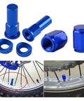 Three Piece Rim Lock Nut Kit For Dirt Bikes And Motocross With Tire Clamp Screws Lock Nuts Spacers Bolts And Valve Caps In Bright Orange Tough As Nails Build Ride Ready And Easy To Install For Secure Rim Fit On Rough Trails displayed and installed on a tire.