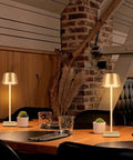 Cordless Table Lamp With Dimmable And Rechargeable Battery on dining table, gold lampshade, ideal for indoor and outdoor use.