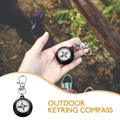 Hand holding Compact Hiking Compass Keychain With Snap Hook Lightweight Plastic Pocket Compass on outdoor trail