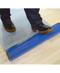 Person stepping on Hard Surface Protection Film 24 Inch By 200 Foot Floor Shield With Self Adhesive Backing And Easy Install On Floor