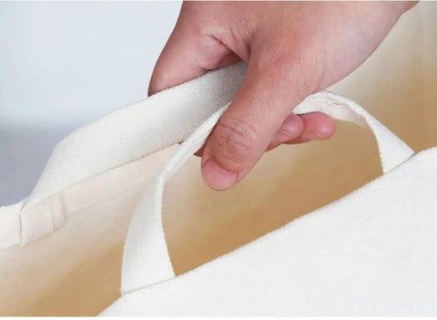 Hand holding the comfort handle of a Slim Fabric Storage Bin With Comfort Handles Narrow Closet Organizers For Shelf And Cabinet Durable Canvas.