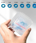 Hand holding 24 Piece M3 Aluminum Shock Tower Mount Washer Kit, shown in transparent box, for Tamiya TT-01 TT-02 XV-01 XV-02 RC cars.