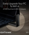 Nighthawk WiFi 6 USB 3.0 Adapter A7500 AX1800 connected to laptop for enhanced WiFi connectivity on wooden desk.