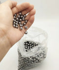 Six Hundred Pcs Seven Sixteenths Inch Steel Balls 11.11mm Precision Bearing Set for Slingshots Carbon Steel AISI 1015 600 Count Each Ball Weighs About 5.6g Silver Finish Beefy Power for Slingshot Action, hand holding silver steel balls