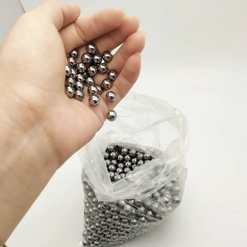 Six Hundred Pcs Seven Sixteenths Inch Steel Balls 11.11mm Precision Bearing Set for Slingshots Carbon Steel AISI 1015 600 Count Each Ball Weighs About 5.6g Silver Finish Beefy Power for Slingshot Action, hand holding silver steel balls