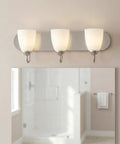 Gather Collection Three Light Bath Vanity Light With Etched Glass Shades In Brushed Nickel Finish installed above bathroom mirror