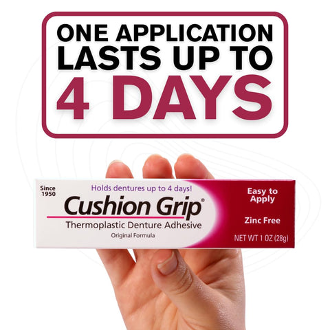 Hand holding Cushion Grip Thermoplastic Denture Adhesive box, 1 oz, zinc-free, indicating long-lasting snug fit for dentures.