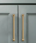 10 Pack 3-Inch Solid Zinc Alloy Cabinet Handles Brushed Gold Finish With Satin Brass Accents installed on grey cupboards