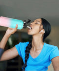 Woman drinking from 64oz Bubble Gum Insulated Stainless Steel Water Bottle With Straw Lid Spout Lid And 3 Lids Leak Proof Vacuum Insulated