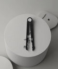 Pro Grade Watch Band Removal Tool Kit With 8 Pins, black heavy duty metal tool on grey surface