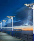 Hella Bright Solar Security Lights Outdoor With Reliable Motion Sensor Technology And IP65 Waterproof Build Perfect For Yard Garage Driveway Featuring 300W Equivalent Kickass Flood Lighting lighting up a wooden pier at dusk.