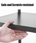 Close-up of hand touching shelf corner on Five-Tier Metal Microwave Storage Rack On Wheels With Side Guardrails, Industrial Style