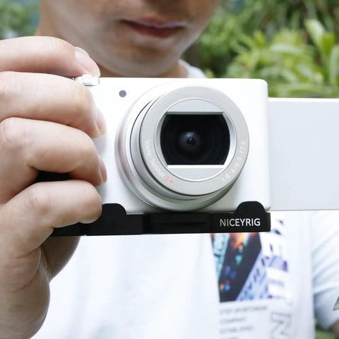 Person holding camera with L-Shaped Grip For Sony ZV-1 II And ZV-1F Vlog Cameras With Black ARCA Extension Bracket and Quick Release Plate