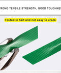 Rock Solid Pet Poly Strapping Roll being tested for strength with pliers, showing durable green plastic and embossed texture.