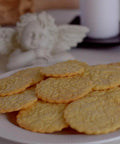 Plate of cookies with embossed patterns made using the Beech Wood Embossed Rolling Pin With Butterflies And Flowers For Cookies And Crafts Handmade Kitchen Tool For Beautiful Patterns Ideal Gift For Mom Or Best Friend Great For Bakers And Hobbyists.