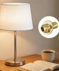 Two Piece Brass Lamp Repair Hardware Kit With 0.98 Inch Brass Pipe, Lock Nuts And Washers in gold tone beside a table lamp