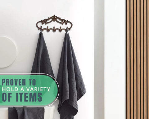 Knockout Five Hook Cast Iron Wall Hanger In Rustic Brown Fleur De Lis Farmhouse Entryway Coat Rack with towels hanging.