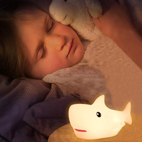 Rechargeable Cute Squishy Shark Night Light For Kids And Teens Soft Silicone Touch Lamp With Gentle Glow next to sleeping child