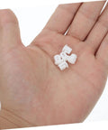 Hand holding 100 Pcs Plastic Hole Plugs White Screw Cap Covers For Cabinets Shelves And Furniture Quick Fix Dust Protection And Reno Boost For Home Office Decor Now