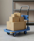 Foldable Cargo Cart Hand Truck With Smooth Steering Casters And Reinforced Frame Portable Trolley For Moving Boxes Blue 90 By 60 Cm Five Inch TPR Silent Wheels Beefy Built Folding Cart For Home Or Warehouse loaded with cardboard boxes