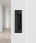 Black stainless steel flush door pull handle on door, part of Two Pack Recessed Finger Flush Door Pulls For Pocket And Sliding Barn Doors.