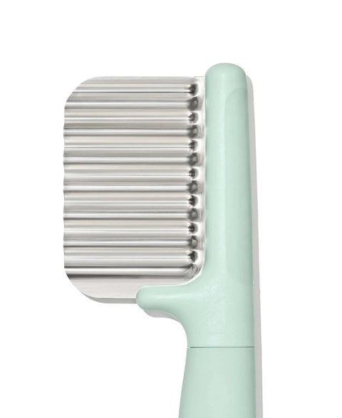 OXO Tot crinkle cutter for kids, mint-green handle with stainless steel ridged blade, close-up view
