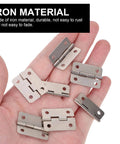 Hand holding 20 Piece Mini Hinge Set For DIY Projects And Handmade Crafts Small Iron Hinges, silver, for cabinets, drawers, chests.