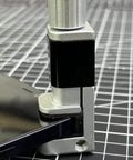 Close-up of adjustable screen repair clamps kit for phones and tablets holding a device screen securely on a grid surface.