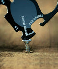 Black 18 Tools In One Credit Card Sized Multitool for Quick Fixes and Everyday Carry; screwdriver in use on wood surface
