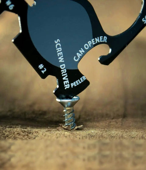 Black 18 Tools In One Credit Card Sized Multitool for Quick Fixes and Everyday Carry; screwdriver in use on wood surface