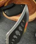 Close-up of the blade of Beast Fixed Blade Axe Knife With Saw Back And Sheath, showing saw-back teeth and black sheath nearby.
