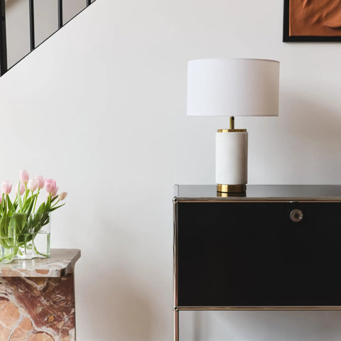 Arden LED Table Lamp With USB Port on black cabinet beside a marble table with tulips, white shade, and brass accents