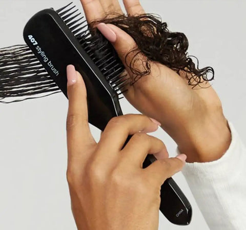 Pro Tools 407 Styling Brush With Nylon Bristles being used on curly hair, showcasing smooth styling on wet or dry hair.