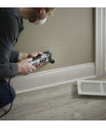 Person using a Reconditioned Corded Oscillating Multi Tool Kit Featuring Durable Metal Frame for cutting drywall.