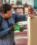 Man using 18V MultiVolt Cordless Stapler Tool Only No Battery For Quick Cabinet And Trim Jobs, wearing safety glasses indoors.