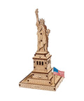 Statue Of Liberty 3D Puzzle Kit, 46 Piece Wooden DIY Model Stands 5.7 Inches, Easy Build No Glue Needed, World Cities Collection, Great Gift For Puzzle Buffs And History Lovers. Front view wooden Statue of Liberty model with U.S. flag.