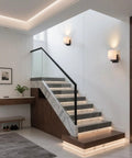 AuroraSpher Indoor Hardwired Modern Milky White Acrylic Black Wall Sconce illuminating a stylish staircase with marble accents.